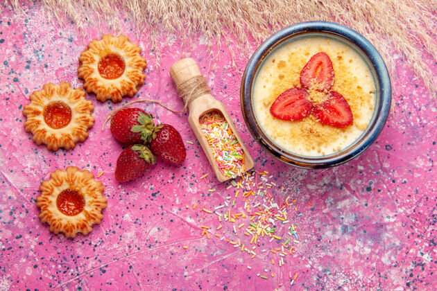 冰淇淋顶视图美味的奶油甜点与红色切片草莓和小饼干浅粉色地板甜点冰淇淋浆果奶油甜水果晚餐美食饼干