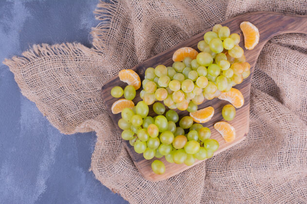 木板一束绿葡萄放在木盘上素食酸味扁豆