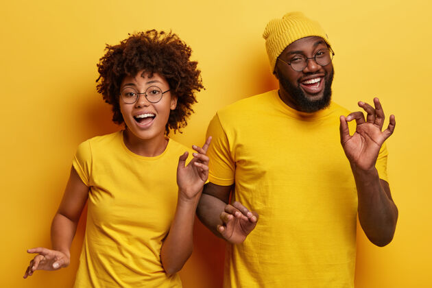 眼镜一对幸福的非洲情侣在黄色的背景下翩翩起舞 积极地移动身体表达男朋友男性