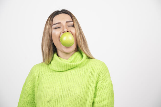 女人穿着绿色t恤的年轻女子正在吃苹果饮食苹果人