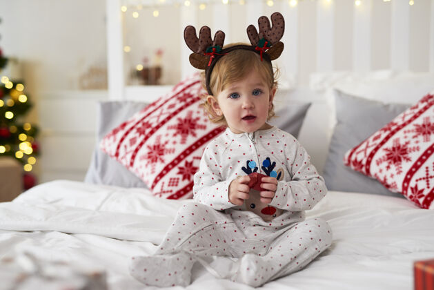 卧室可爱的婴儿肖像与圣诞礼物女孩装饰孩子