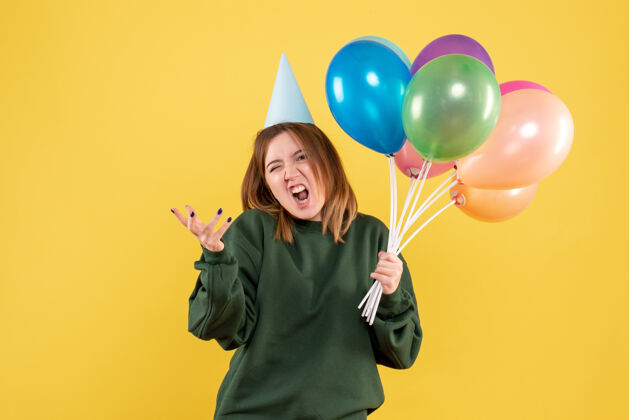 聚会正面图是一位年轻的女士 手里拿着五颜六色的气球庆祝乐趣女人