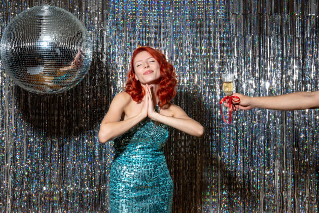年轻年轻的女性在庆祝新年 男性在闪亮的窗帘上建议她的香槟女士新舞蹈