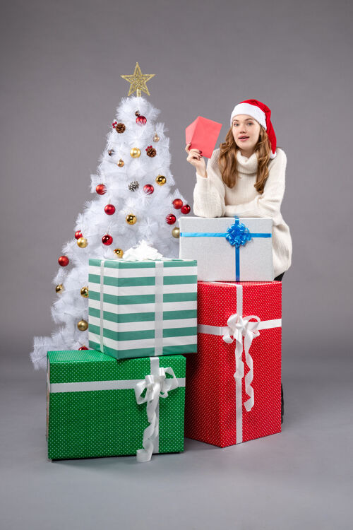 圣诞树拿着信封的年轻女人年轻圣诞包