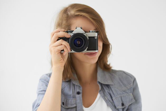 成人人 生活方式和技术概念摄影棚拍摄的时尚女孩拿着胶卷相机在她的脸上 你的照片年轻的女摄影师使用老式设备拍照镜头看爱好