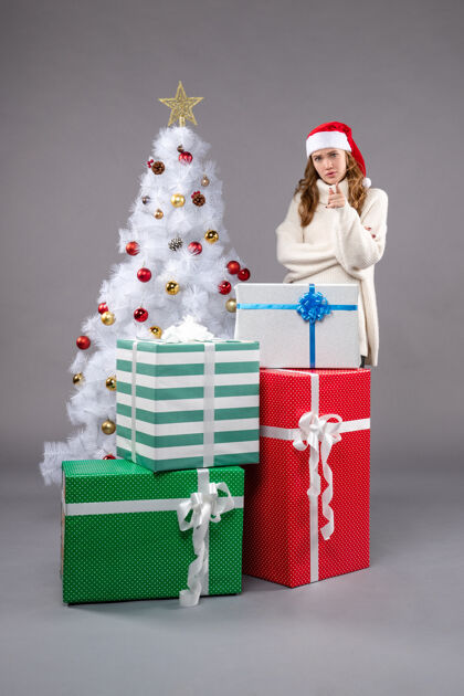 购物年轻的女性在灰色的礼物时尚圣诞树包