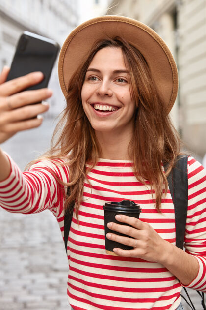 智能手机很高兴旅行者点击自拍照片 制作新图片 使用手机和应用程序积极休息女士