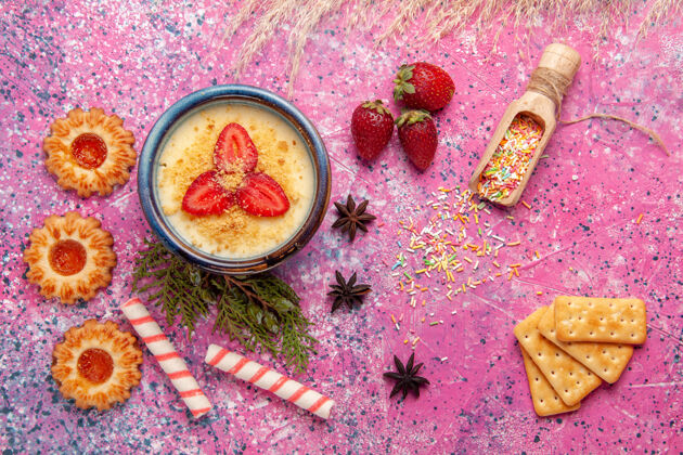 草莓顶视图美味奶油甜点与红色切片草莓和饼干浅粉色背景甜点冰淇淋浆果奶油甜水果切片的灯光奶油状的