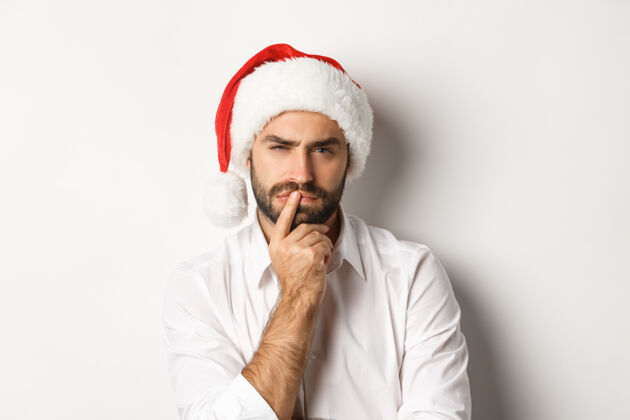 胡须派对 寒假和庆祝的概念严肃的男人想着圣诞节和新年 戴着圣诞帽思考脸节日