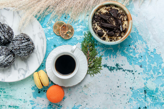 饼干俯瞰一杯咖啡 配上法式马卡龙和巧克力蛋糕 背景为浅蓝色蛋糕烘焙饼干甜巧克力糖色马克杯茶咖啡