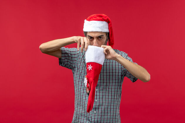 成人红墙上穿着圣诞袜的年轻人的正视图前面情感节日