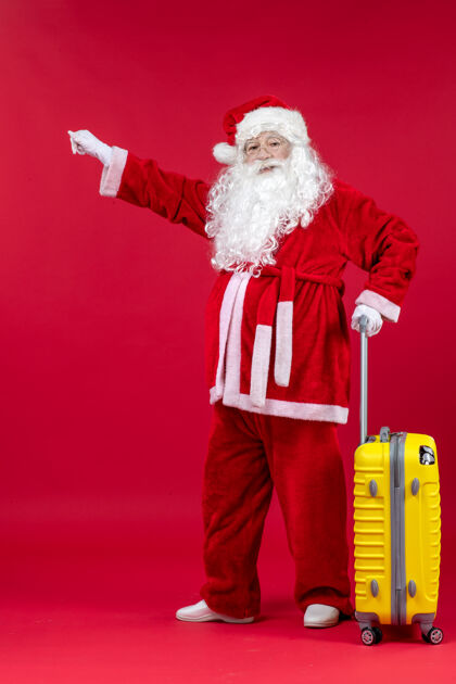 圣诞红墙上准备旅行的黄包圣诞老人的正视图时尚圣诞老人节日