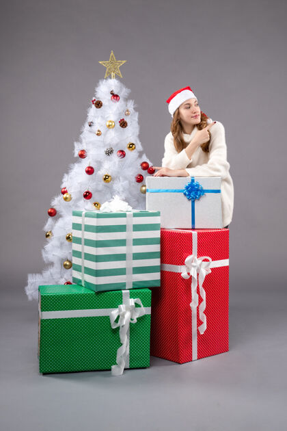礼物年轻的女性在灰色的圣诞礼物周围圣诞树圣诞老人礼物
