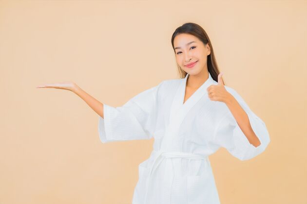 模特肖像美丽的亚洲年轻女子穿着米色的微笑浴袍身体成人女性