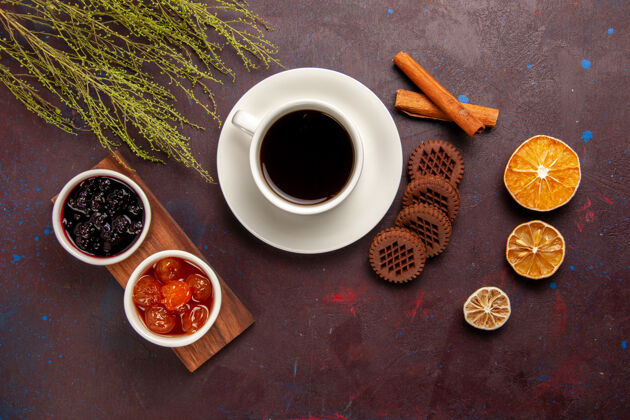 顶部顶视图咖啡杯不同果酱和巧克力饼干上的黑办公桌果酱果酱甜饮料视野水果