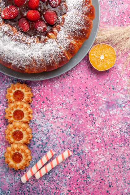 顶部俯瞰美味的草莓蛋糕糖粉蛋糕 粉色桌上有饼干蛋糕甜甜的糖饼干馅饼派曲奇美食