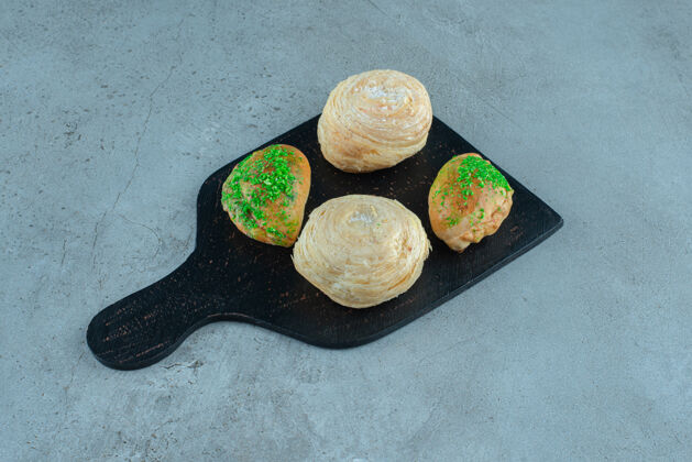 甜点在大理石表面的木板上放上薄饼和小面包糖蛋糕开胃