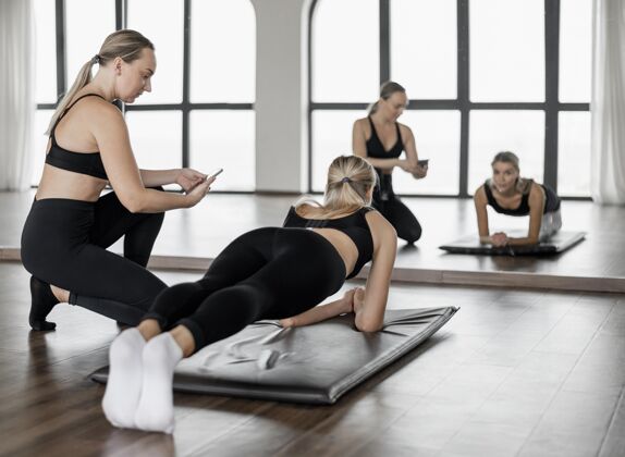 运动在健身房与私人教练一起锻炼运动计划客户