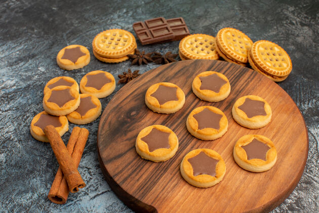 货币木盘上的饼干和灰色的肉桂和巧克力的近距离侧向射击棕色可食用坚果货币