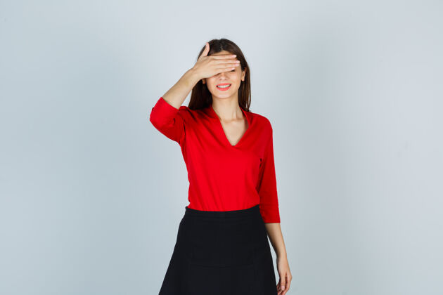 封面一位年轻的女士手捂眼睛 穿着红衬衫 黑裙子 看上去很快乐微笑人眼睛
