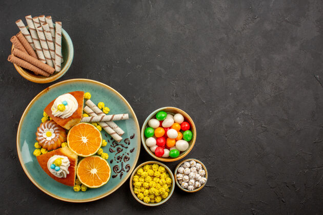 水果顶视图美味的派片与新鲜的橘子和糖果在黑暗中饼干托盘派