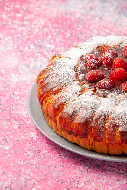 餐正面图美味的草莓蛋糕用糖粉烤在浅粉色的蛋糕表面甜甜的糖饼干饼干馅饼草莓水果新鲜