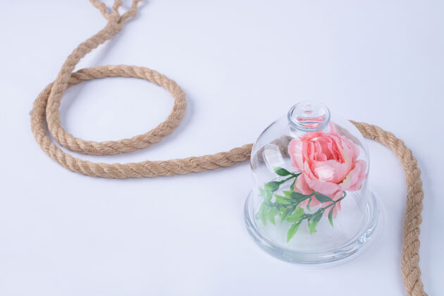 叶子玫瑰在玻璃杯中 白色表面有绳子花粉彩花
