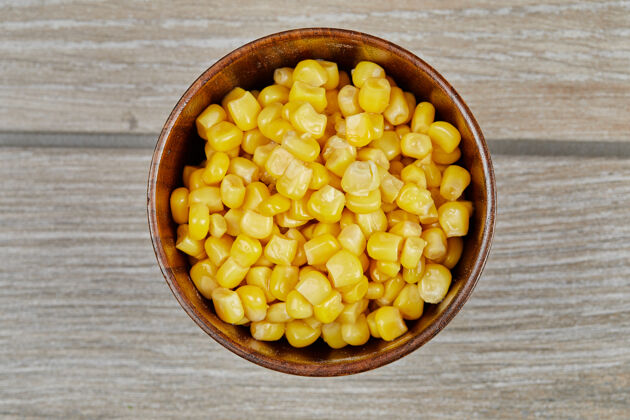 黄色一碗煮好的甜玉米放在木桌上木制美味谷物