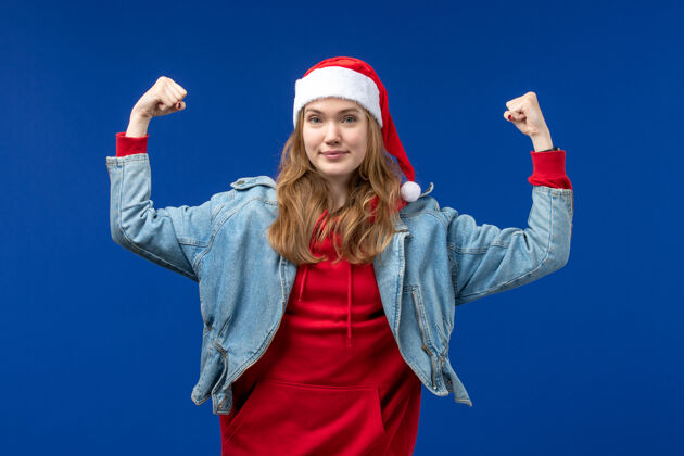 肖像前视图年轻女性在蓝色背景上微笑着 感慨圣诞节的节日色彩圣诞节成年人开朗