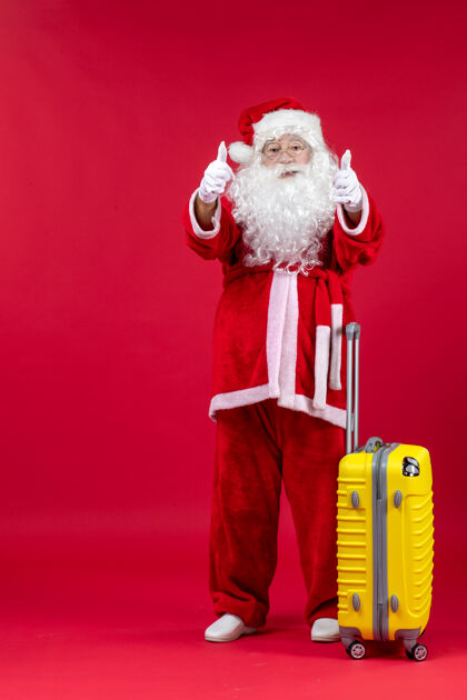 十二月红墙上准备旅行的黄包圣诞老人的正视图表情圣诞老人人