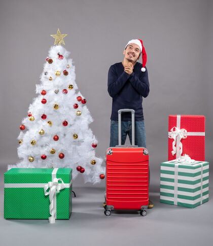 玩具圣诞老人戴着圣诞帽 站在圣诞树旁 圣诞玩具五颜六色庆祝盒子圣诞帽