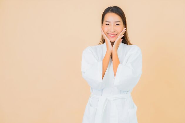 头部肖像美丽的亚洲年轻女子穿着米色的微笑浴袍亚洲清洁模特