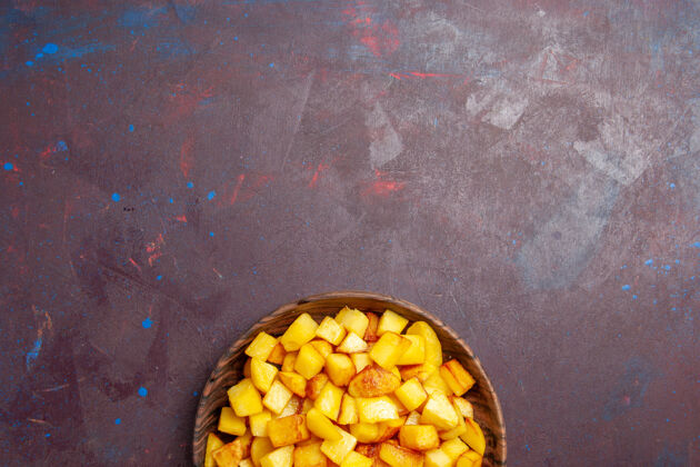 玉米俯视图切熟的土豆在棕色盘子里的黑暗盘子土豆食物