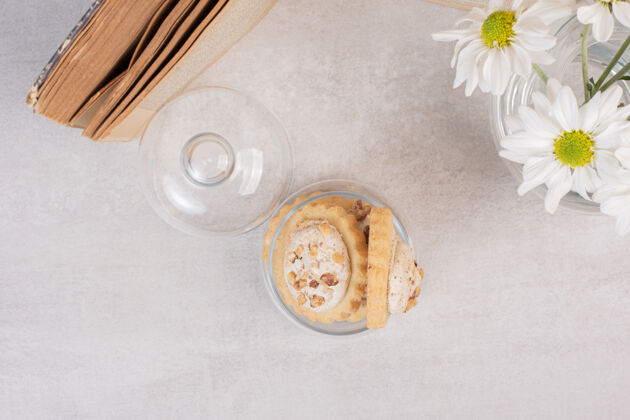 自制燕麦葡萄干曲奇在玻璃罐 书和雏菊甜点饼干零食