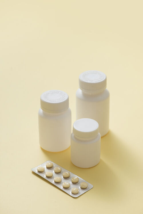 病人白色的药片 黄色的表面有不同类型的白色药片药物药品瓶子