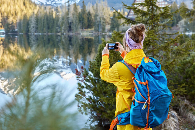 木头自由旅行者拍摄风景优美的自然景观 试图捕捉美丽的湖光山色 退后电话采取背包客