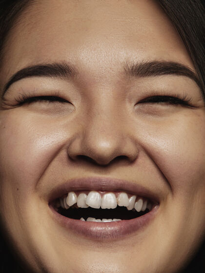 单身年轻而富有感情的中国女性的特写肖像女性模特的高细节照片 保持良好的皮肤和明亮的面部表情人类情感的概念对着镜头微笑人年轻迷人