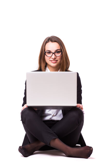 休闲年轻的女商人坐在地板上 用笔记本电脑隔离在白墙上成功女商人个人电脑