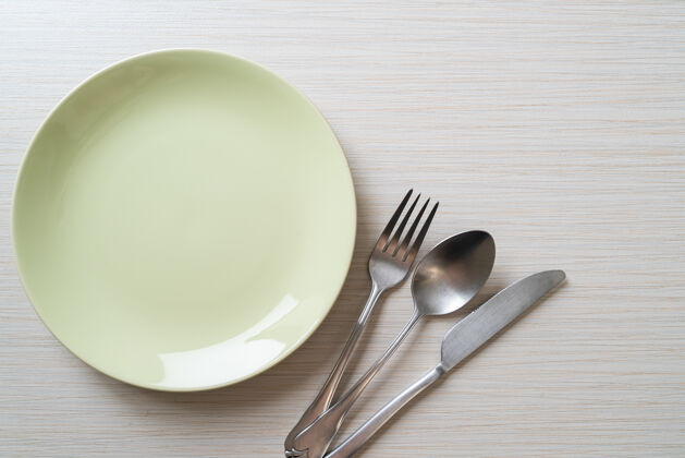 不锈钢在木桌上放一个空盘子或盘子 里面有刀叉和勺子用餐叉子器皿