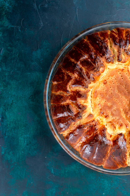 蛋糕顶视图美味的烤蛋糕圆形形成甜内浅蓝色背景上的玻璃锅美味午餐食物