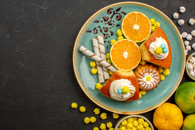 葡萄柚在黑暗的桌子上俯瞰派片和切成片的新鲜橘子和糖果茶食品水果