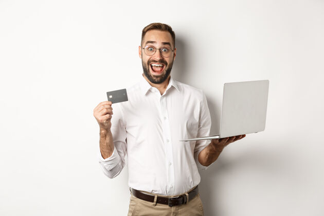 成人网上购物帅哥出示信用卡 用笔记本电脑在网上点菜 站着电子商务信用卡买家