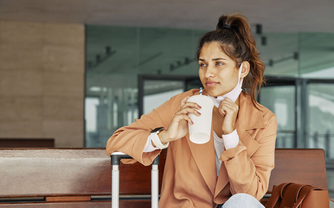 病毒大流行期间在机场喝咖啡的女人流行病女性女性