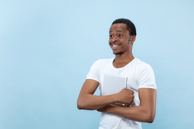 手势穿着白衬衫的非洲裔美国年轻人的特写肖像人类的情感 面部表情 广告 销售理念手持平板电脑 微笑看起来很开心手成人选择