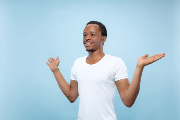 快乐穿着白衬衫的非洲裔美国年轻人的特写肖像展示空酒吧 指向 选择 邀请人男性显示