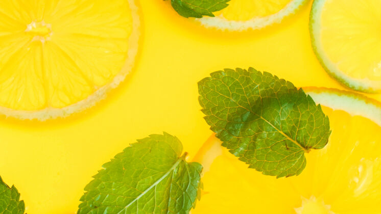 多汁薄荷叶和橙汁片在柠檬水或新鲜橙汁的俯视图新鲜玻璃桌子