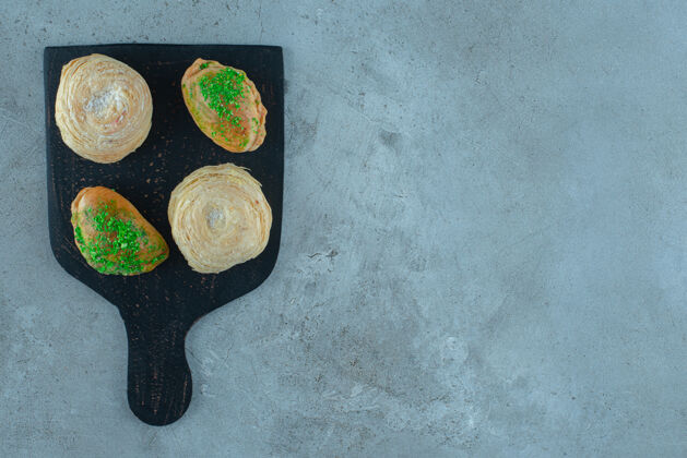 美味在大理石表面的木板上放上小面包和薄饼美味甜点开胃