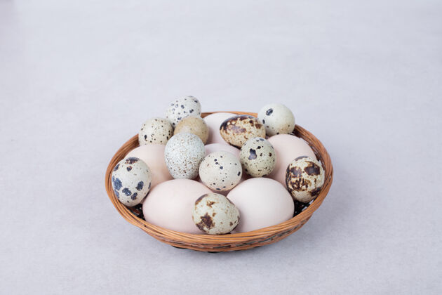 天然鹌鹑蛋和鸡蛋放在白色的碗里生的有机鹌鹑