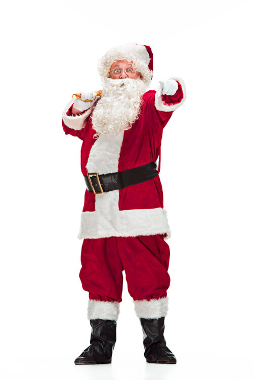肖像一个穿着圣诞老人服装的人的肖像-一个豪华的白胡子 圣诞老人的帽子和一个红色的服装-在一个白色的背景上孤立的全长手手帽子