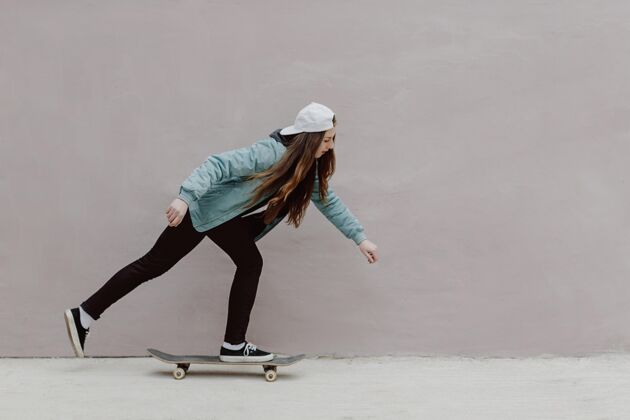 滑板女孩滑冰女孩骑着她的滑板女孩户外滑板